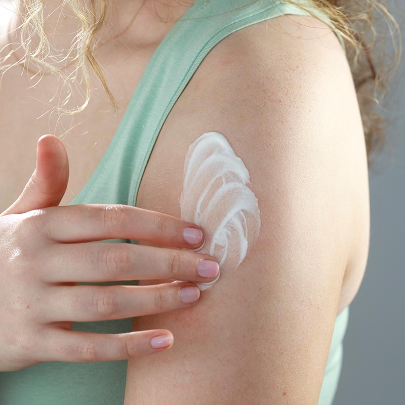 Lady applying Bragan Skincare's body cream to her arm