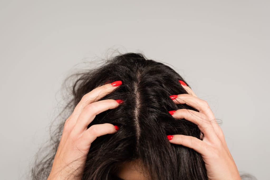 Woman massaging scalp while using psoriasis shampoo