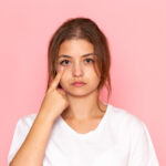 girl pointing to her eyelid